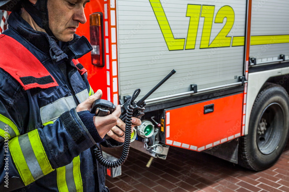 Fototapeta premium Feuerwehrmann im Einsatz mit Funkgerät