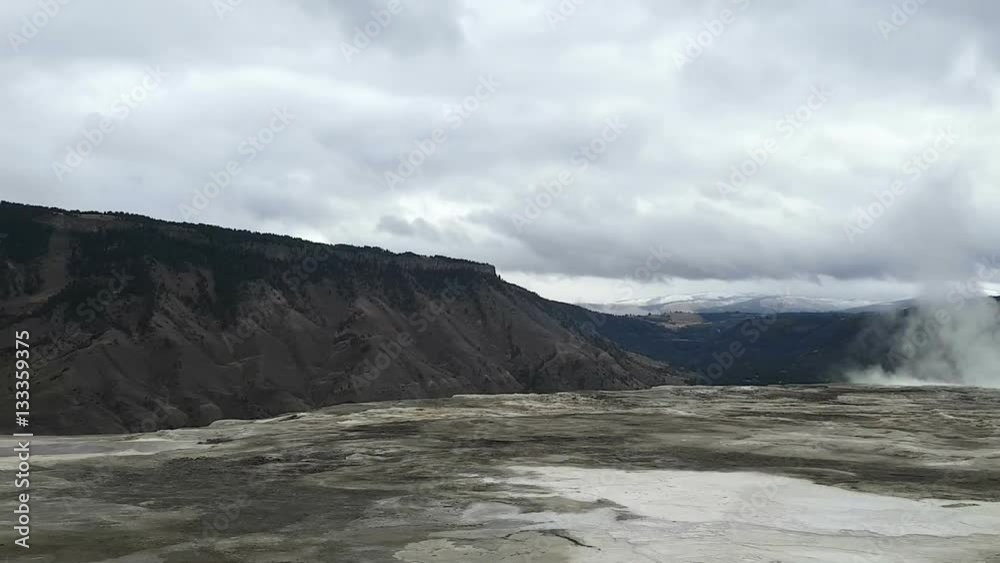 Zooming pan timelapse of a smoking geysers and north entrance, filmed from the top of mammoth hot springs, in Yellowstone national park, in Wyoming, United states of america