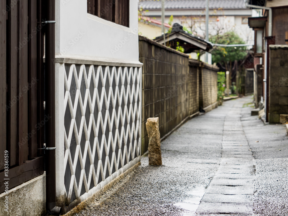 Old style East Asian alley with lattice pattern wall on a rainy day