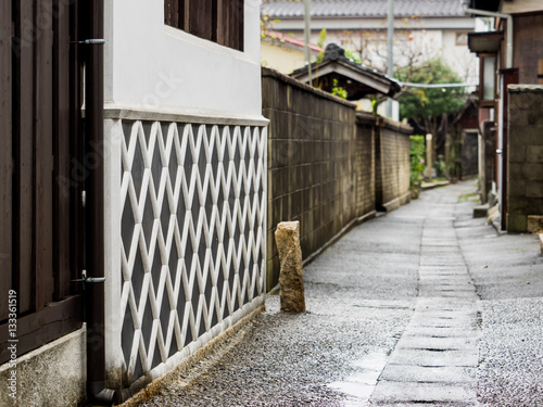 Old style East Asian alley with lattice pattern wall on a rainy day