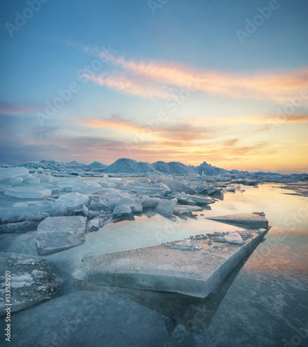 Frozen sea during sunset. Beautiful natural seascape in the winter time