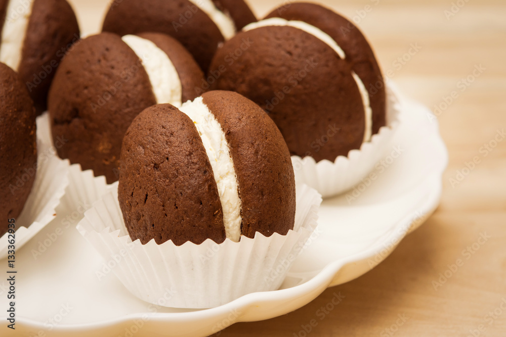 macaroon small round chocolate cake lies in a plate macaroon small round chocolate cake lies in a plate