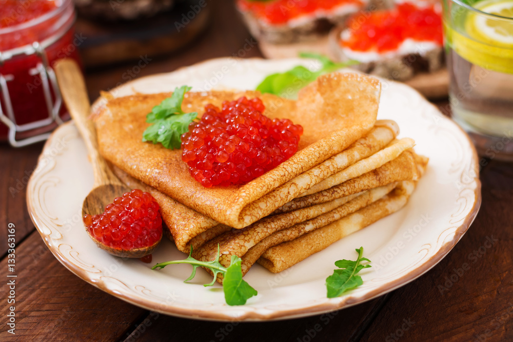 Pancakes with red caviar on plate. Russian cuisine. Maslenitsa Pancakes with red caviar on plate. Russian cuisine. Maslenitsa