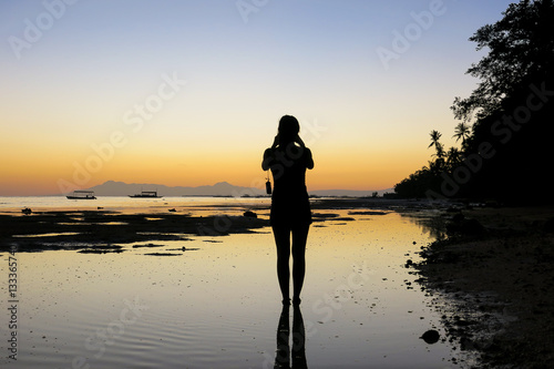 Woman Taking Sunset Pictures on Beach