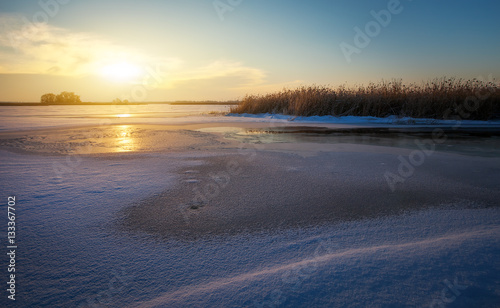 Winter landscape with river and sunset sky. Composition of nature