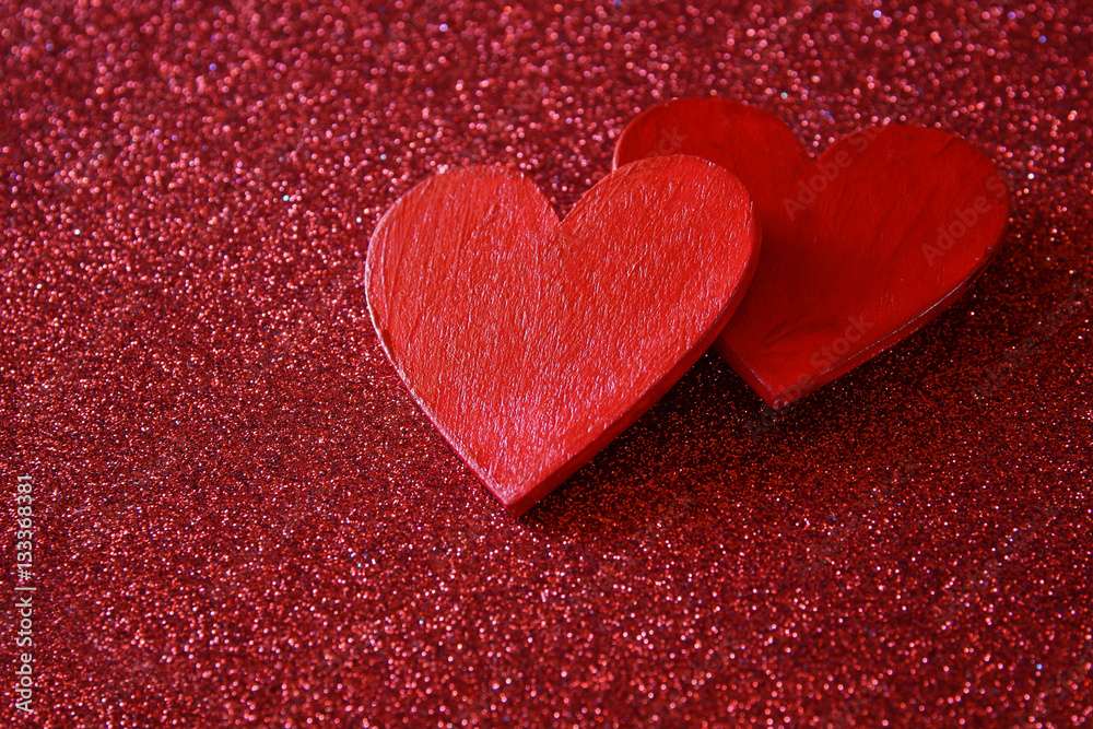 Obraz premium Wooden red hearts on red shiny background