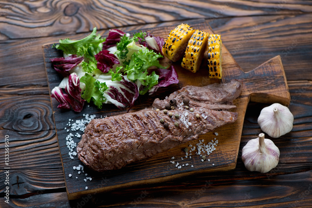 Grilled machete steak with vegetables in a rustic wooden setting