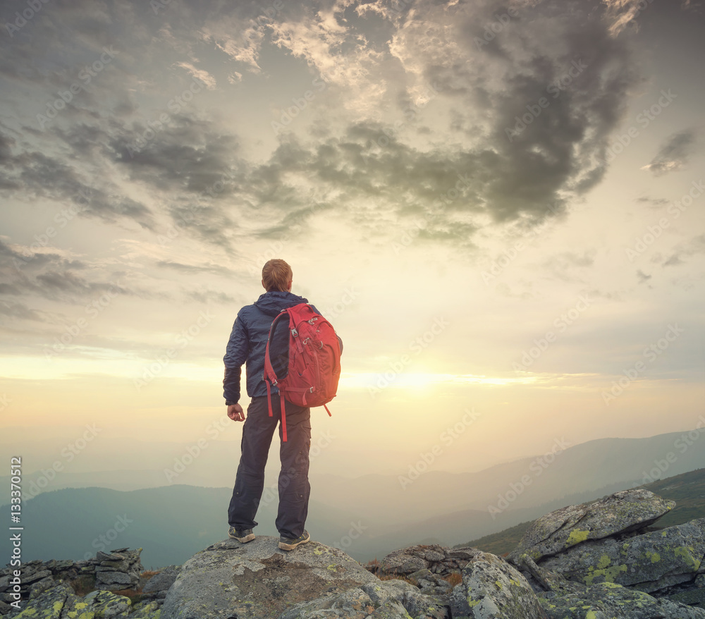 Obraz premium Tourist on the peak of high rocks. Sport and active life concept.