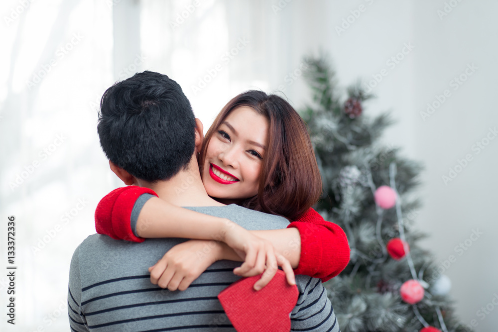 Christmas Asian Couple. A handsome man giving her girlfriend/wif Christmas Asian Couple. A handsome man giving her girlfriend/wif