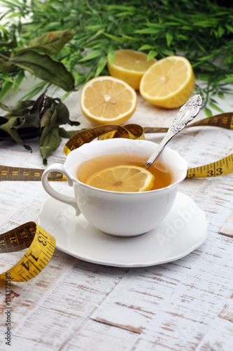 ginger tea - fitness liefestyle concept with tea, dumbells and measure tape