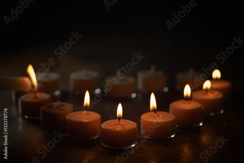 setting tealight candles in a shape of a heart, shallow focus photo