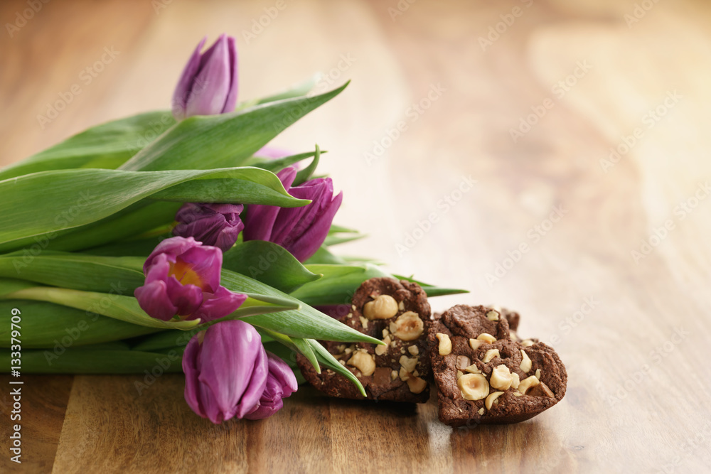 bouquet of purple tulips on wood table with homemade chocolate cookies for valentines day, shallow dof bouquet of purple tulips on wood table with homemade chocolate cookies for valentines day, shallow dof