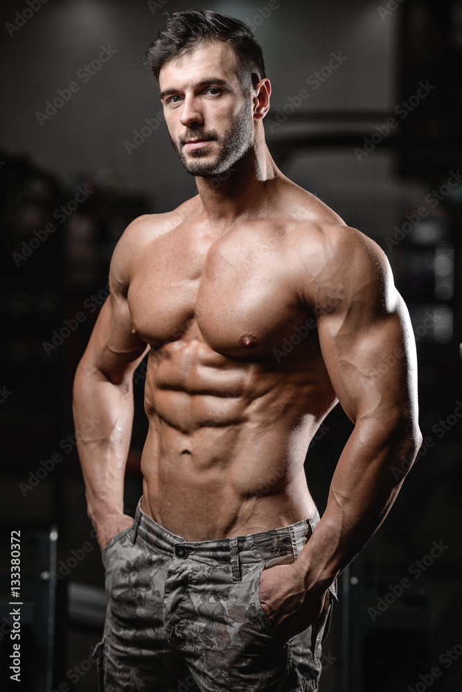 Fototapeta premium Strong and handsome athletic young man muscles abs and biceps.