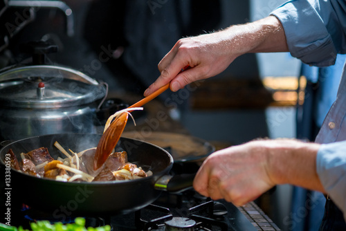 Εκτύπωση καμβά Man mixing the meat in a frying pan shovel
