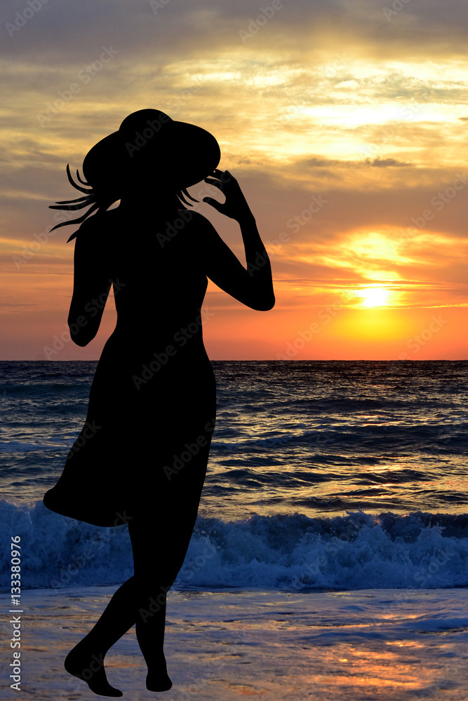 Woman on the beach looking at the sunrise