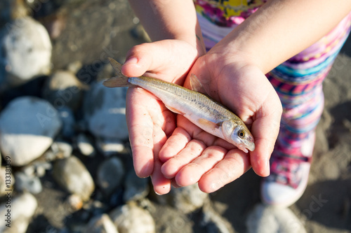 The girl holds live fish