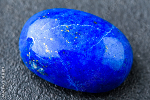 Foto Rich blue lapis lazuli oval cabochon with small golden spots.