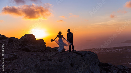 Silhouette of bride and groom on sea sunset