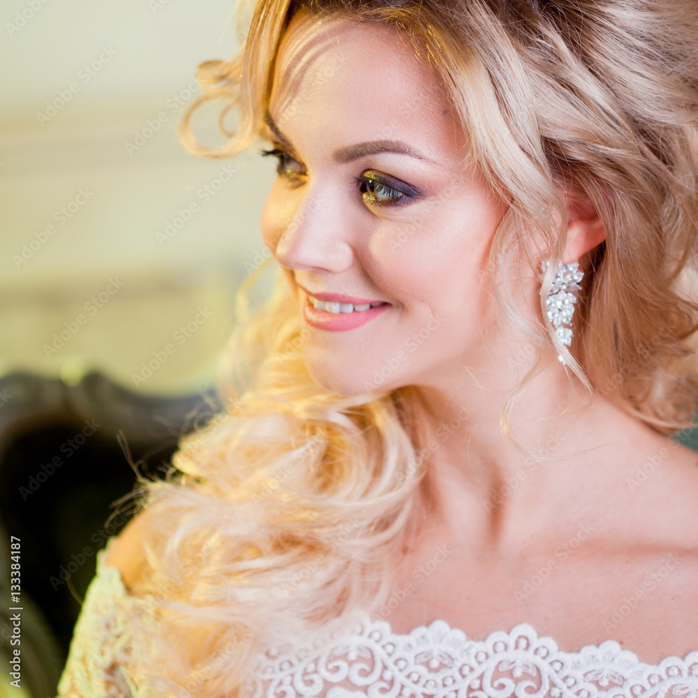 Portrait of charming woman in wedding dress. The girl bride sits in a chair Portrait of charming woman in wedding dress. The girl bride sits in a chair