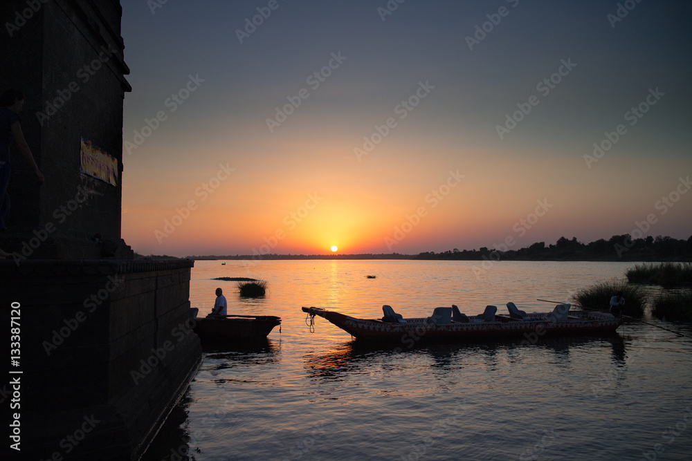 Sonnenuntergang über indischem Fluss mit Boot