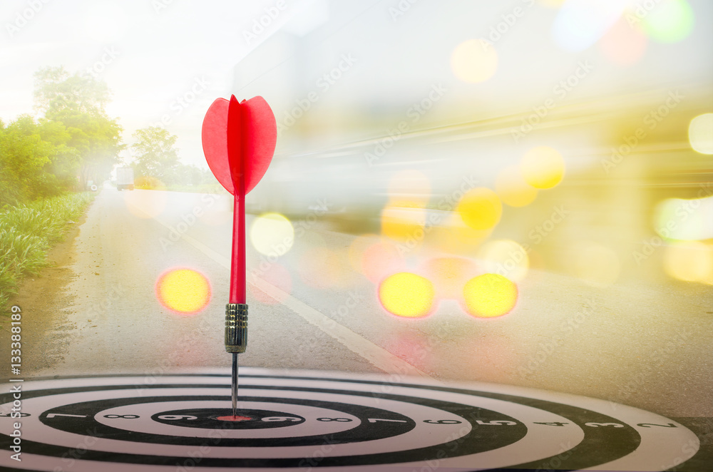 Close up shot red dart arrow on center of dartboard with transpo Close up shot red dart arrow on center of dartboard with transpo