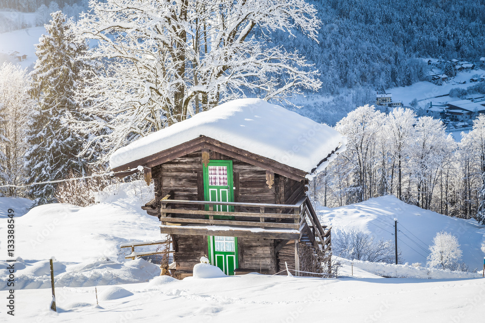 Traditional wooden mountain chalet in scenic winter wonderland scenery in the Alps