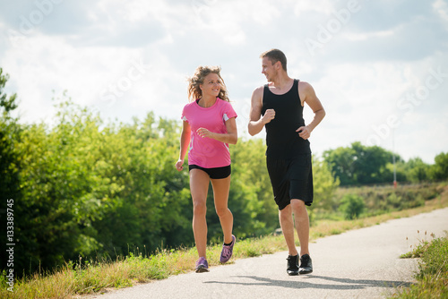 Portrait of cheerful couple running outdoors