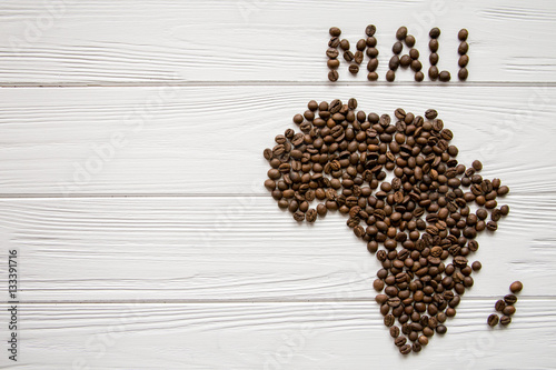 Map of the Africa made of roasted coffee beans and cup of coffee on white wooden textured background with space for text