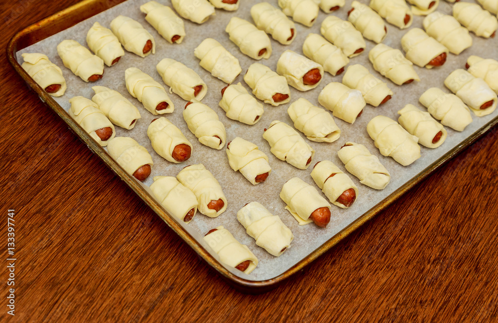 Close up of plate with fresh homemade pigs in blanket on a table Close up of plate with fresh homemade pigs in blanket on a table