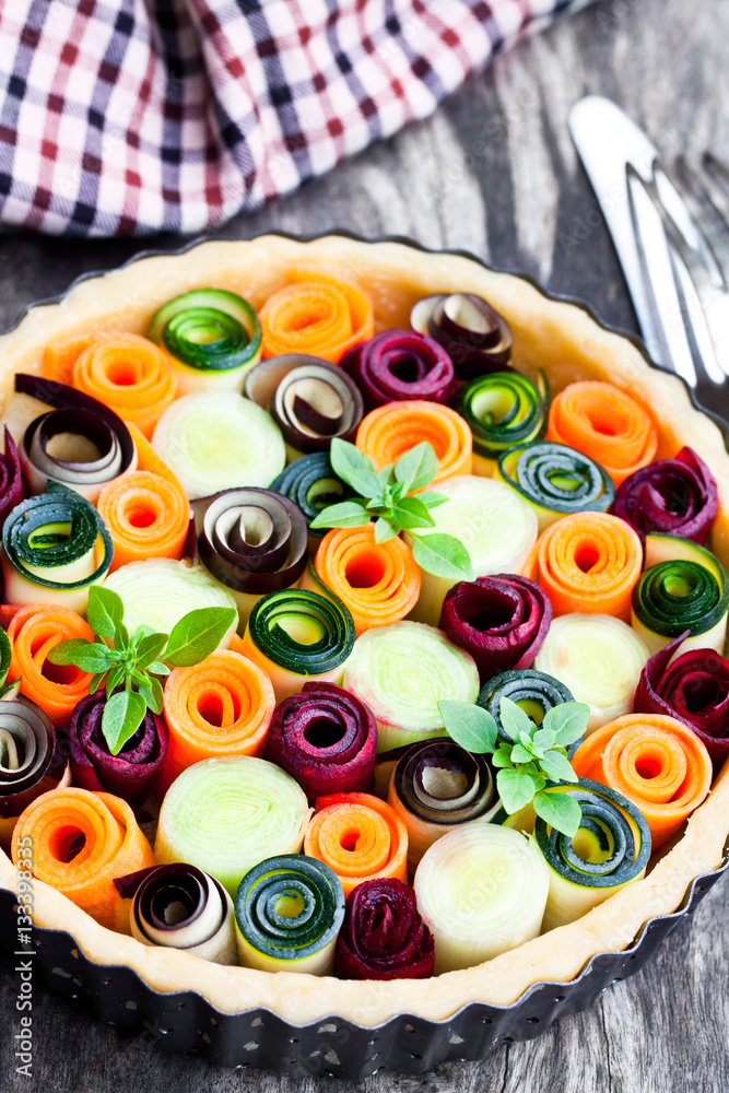 Raw  homemade vegetarian pie with colored vegetables. Ready for