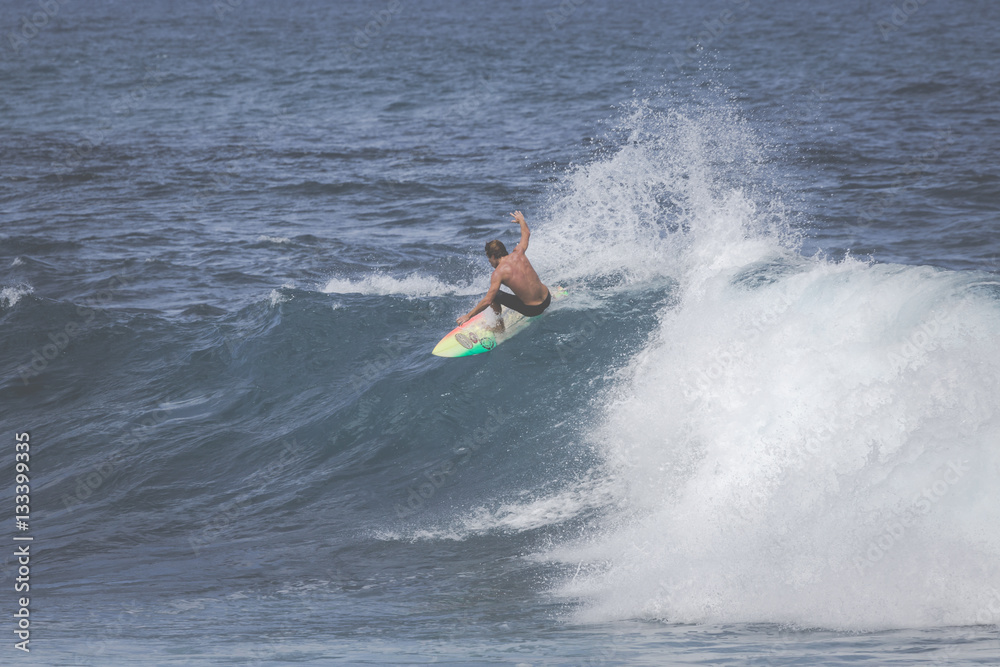 Professional surfer rides a giant wave at the legendary big wave surf break Professional surfer rides a giant wave at the legendary big wave surf break