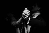 couple dancing on a dark background. focus on hands
