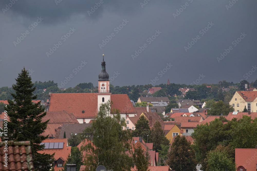 Hilpoltstein with Catholic parish church St. Johann Baptist under stormy sky