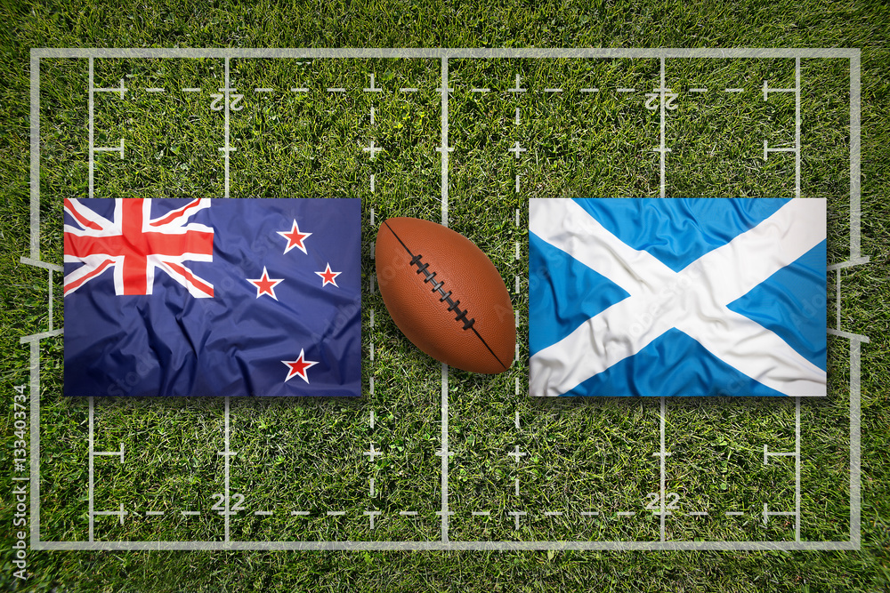 Obraz premium New Zealand vs. Scotland flags on rugby field