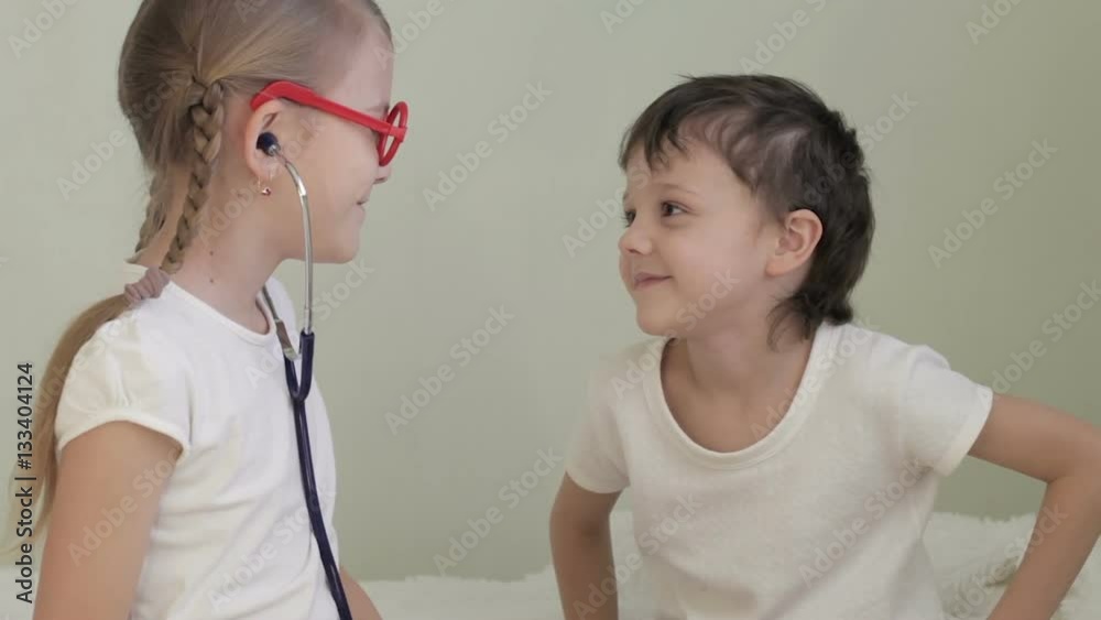 Little doctor examining boy with stethoscope