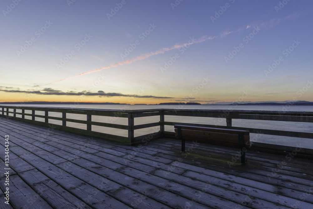 Bench on a frosty dock with strong lines and a colorful sky.Vancouver Island Canada