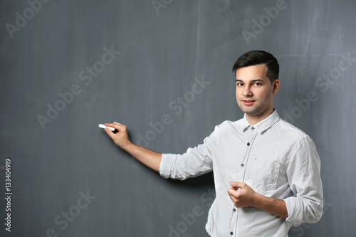 Handsome young teacher stan...