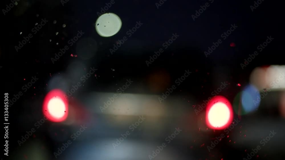 Driving at Night. Windshield View and Blurred Cars in City. Blurry and Rainy View From Car Window Driving at Night. Windshield View and Blurred Cars in City. Blurry and Rainy View From Car Window