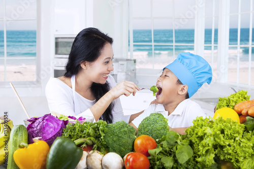 Asian woman gives her son healthy food