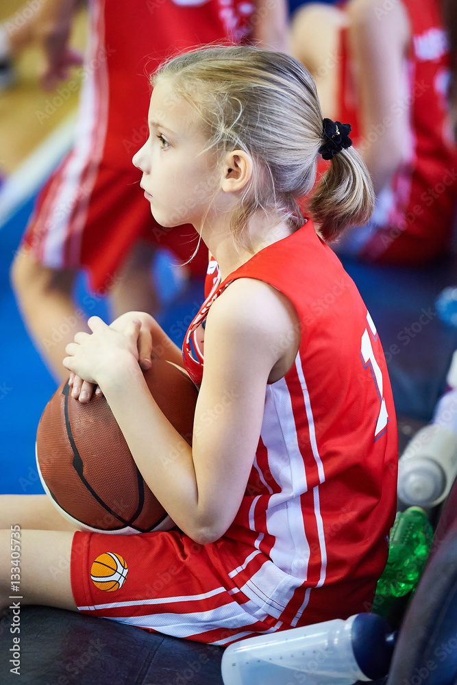 Fototapeta premium Girl athlete with basketball sitting on bench