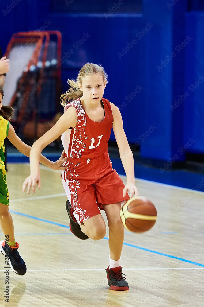 Fototapeta premium Girl athlete in uniform playing basketball