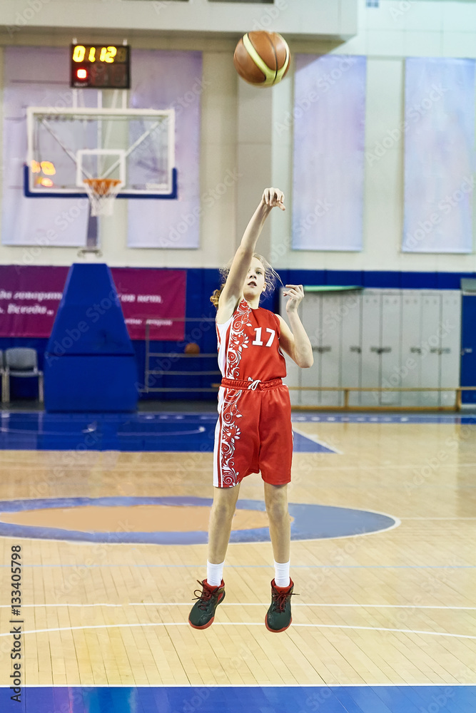 Obraz premium Girl athlete in uniform playing basketball