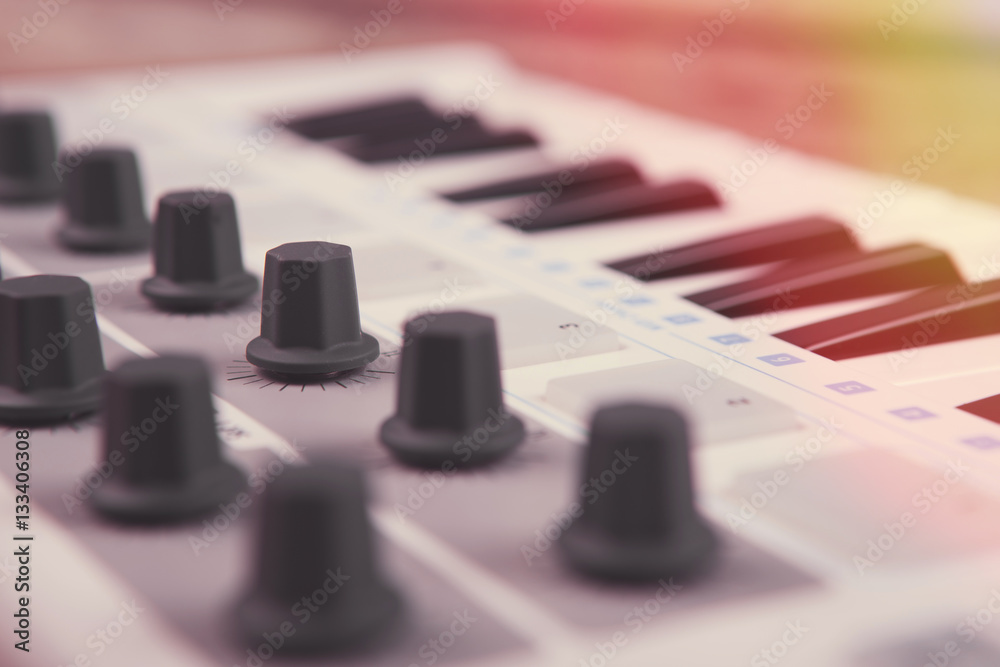 Close up of MIDI controller volume fader, knob and keys. Close up of MIDI controller volume fader, knob and keys.