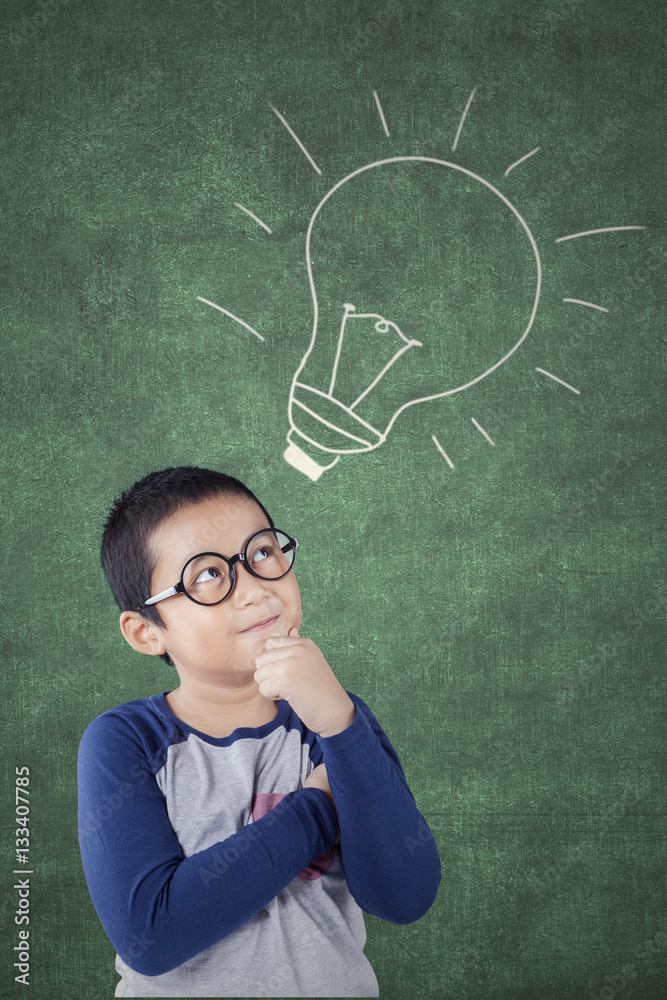 Elementary student looking at lamp on chalkboard