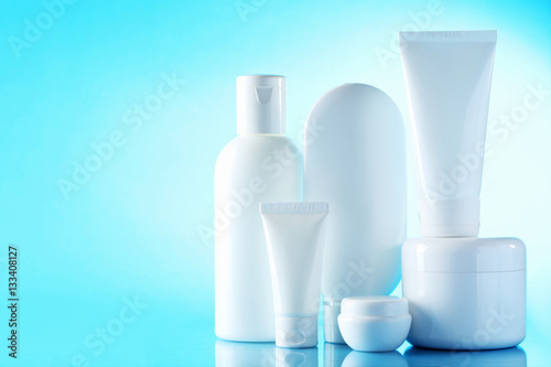 White cosmetic bottles on a blue background