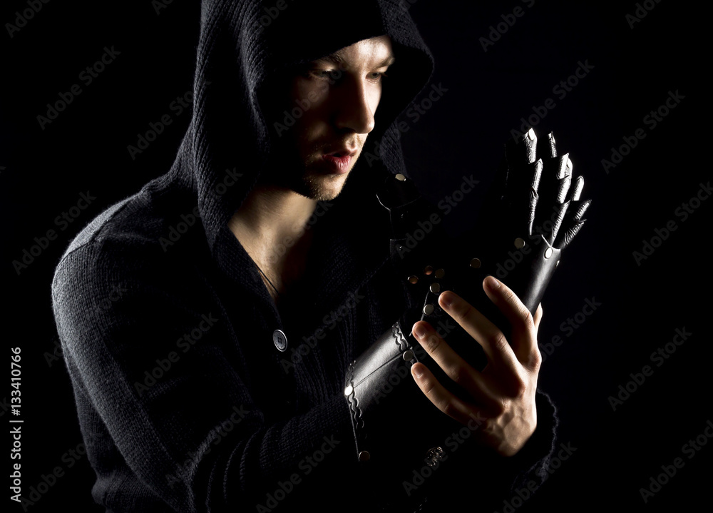 Emotional, young and attractive assassin in gloves on the black Emotional, young and attractive assassin in gloves on the black