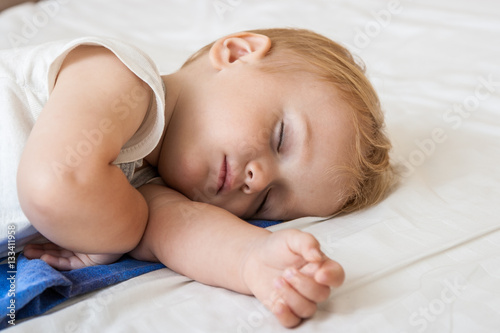 Close-up portrait of a beautiful sleeping baby on bed