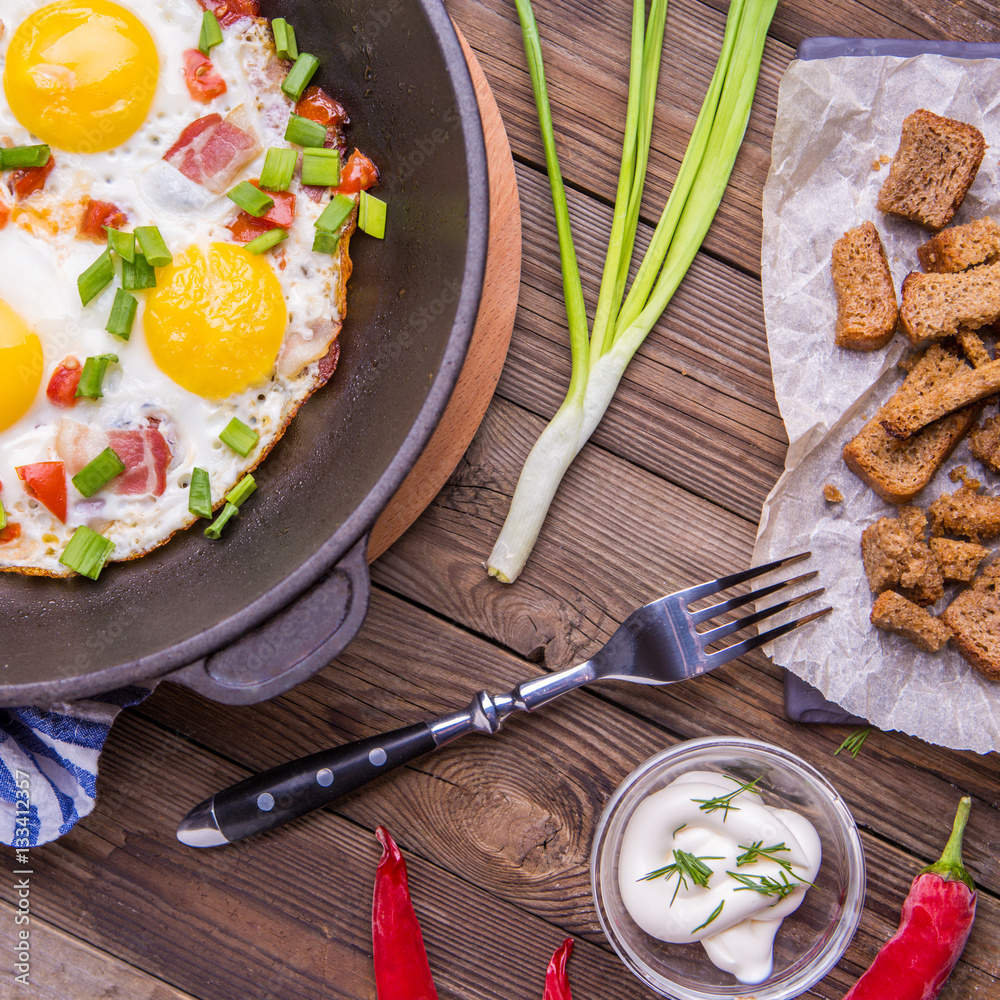 Fried eggs in pan with tomatoes and green fresh onion. Fried eggs in pan with tomatoes and green fresh onion.