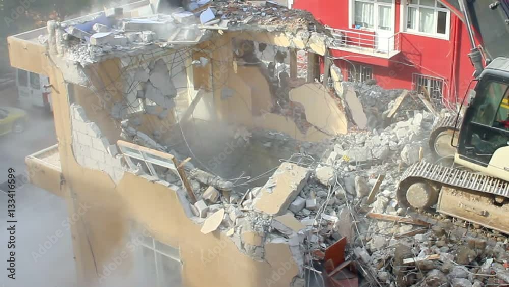Tearing down old building on a construction site. Concrete dust released by a building demolition is a major source of dangerous air pollution. Some substances in concrete can cause health concerns du Tearing down old building on a construction site. Concrete dust released by a building demolition is a major source of dangerous air pollution. Some substances in concrete can cause health concerns du