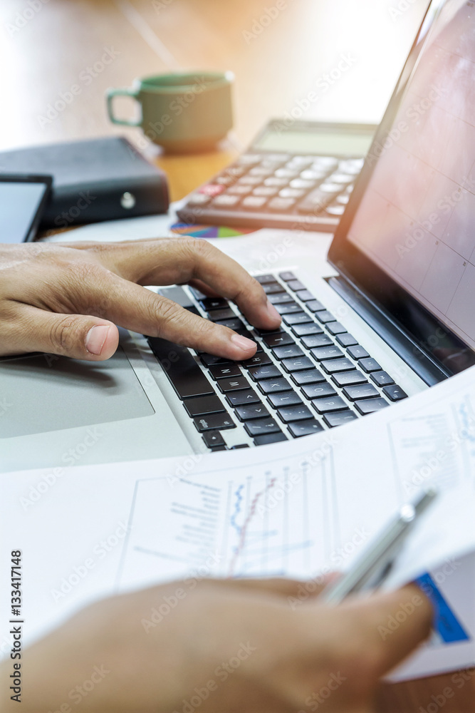 Businessman working with laptop and documents in office
